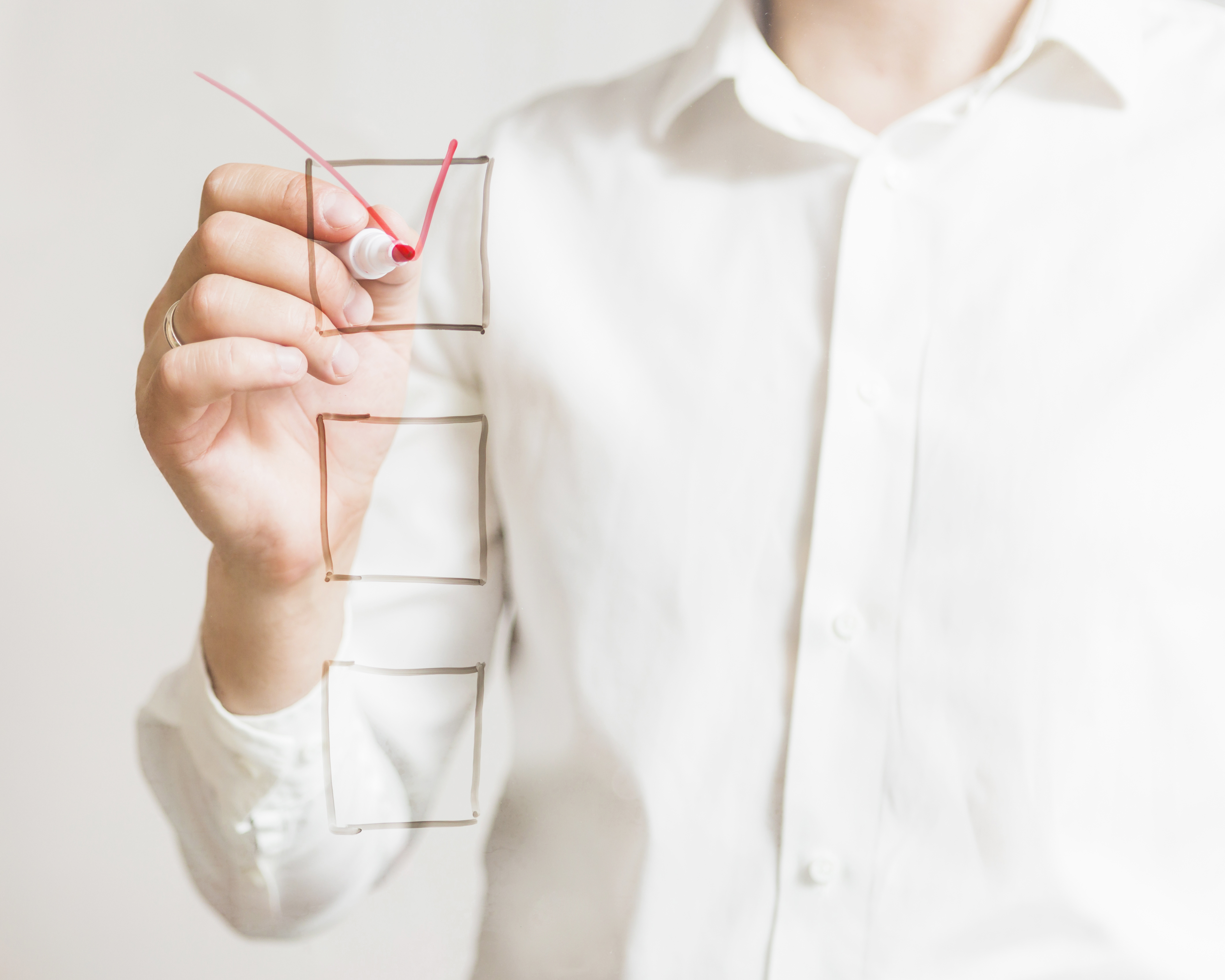 businessperson-s-hand-marking-check-box-with-red-marker-screen