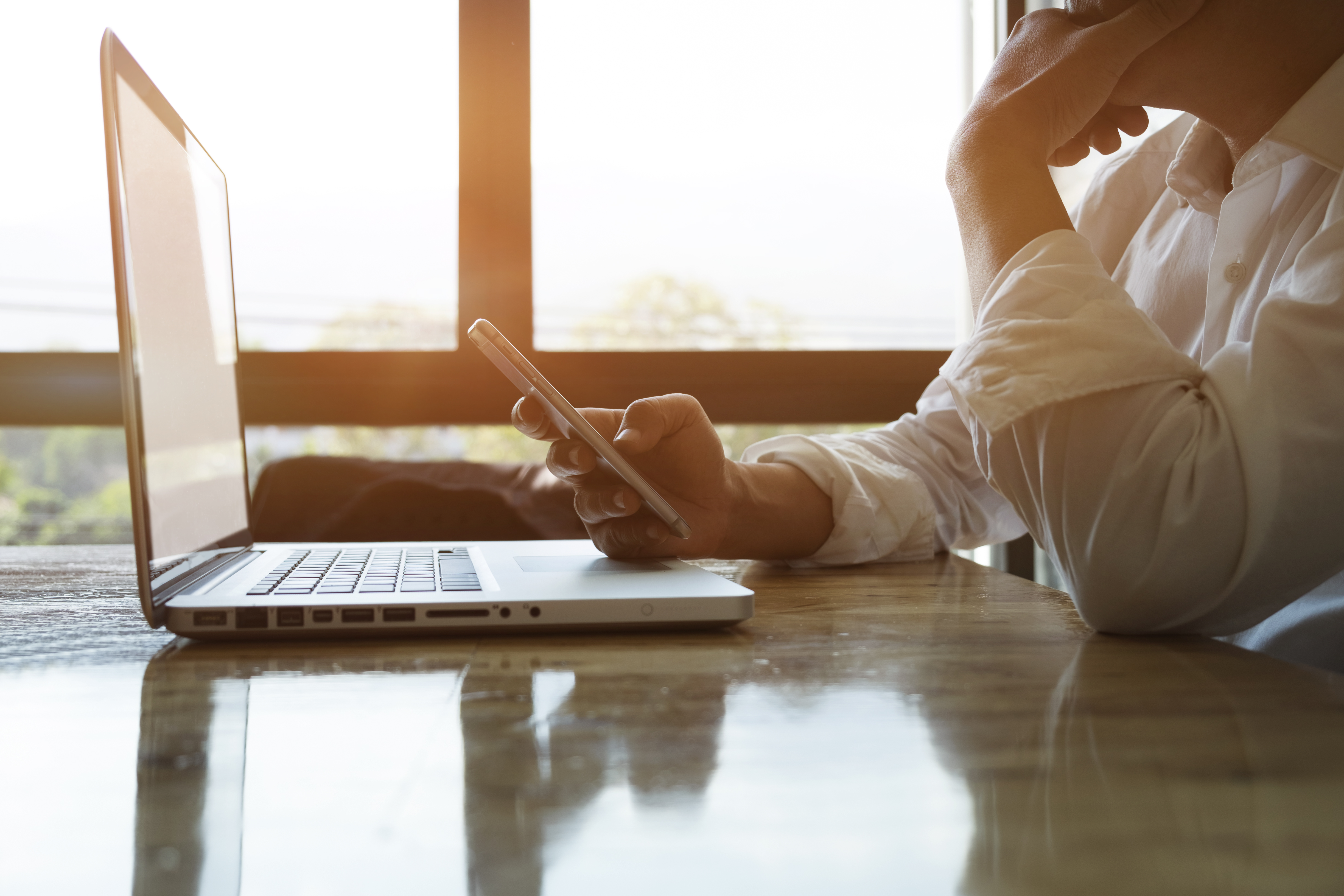 thoughtful-businessman-experienced-entrepreneur-using-smartphone-laptop-analize-information-xd