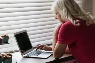 mature_woman_using_laptop_near_window_1_2x